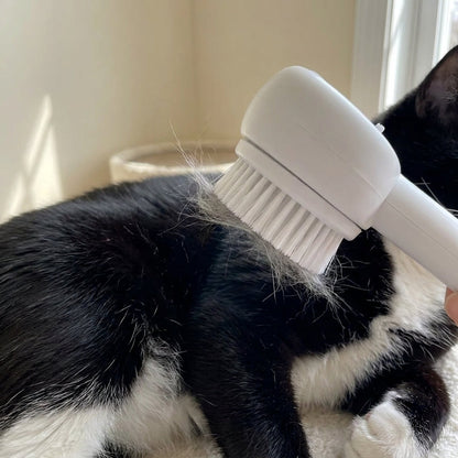 Close-up of the SteamGroom brush head pulling loose grey fur from a tuxedo cat's coat
